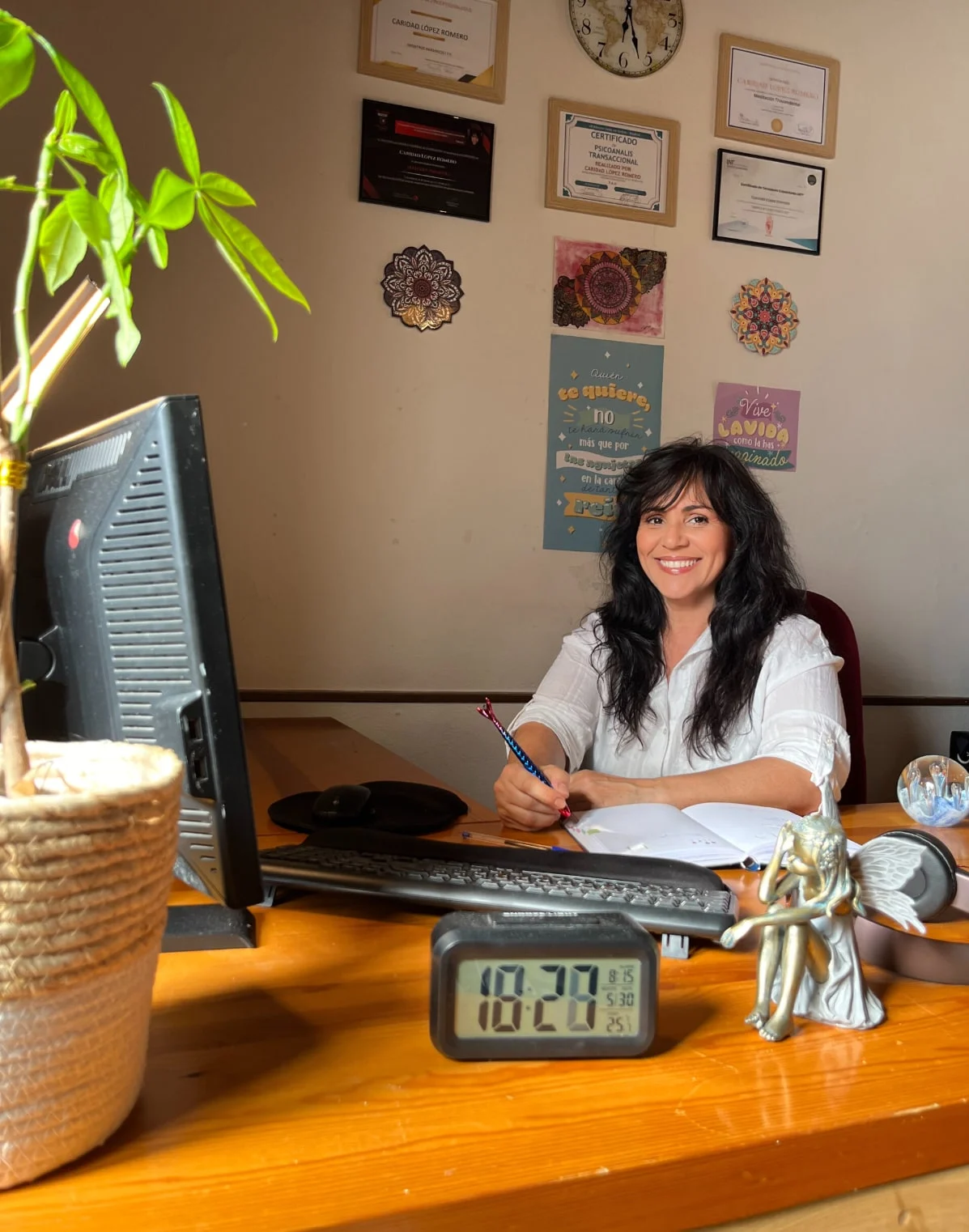 Caridad López en su consulta de Chapinería con sus diplomas y mandalas
